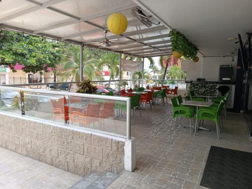 巴兰基亚Hotel Prado 53的一间带绿色桌椅和柜台的餐厅