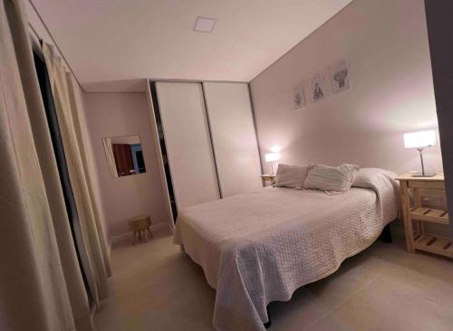 罗萨里奥Depto acogedor, moderno y espacioso的一间小卧室,配有一张床和一张桌子