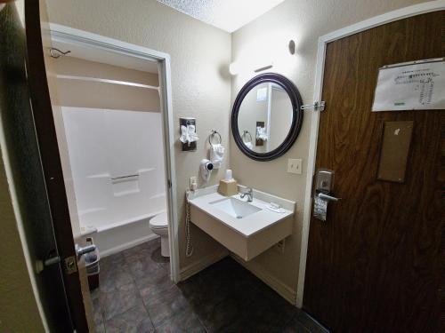 嘉年丰年速8酒店的一间带水槽、镜子和卫生间的浴室