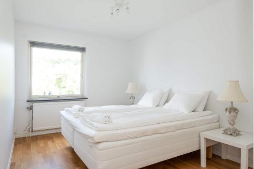哥德堡WHITE & BRIGHT Room in a shared apartment的白色的窗户客房内的一张白色的床