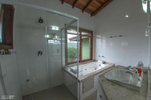 因比图巴Bangalôs do Rosa-Praia do Rosa的带浴缸、水槽和淋浴的浴室