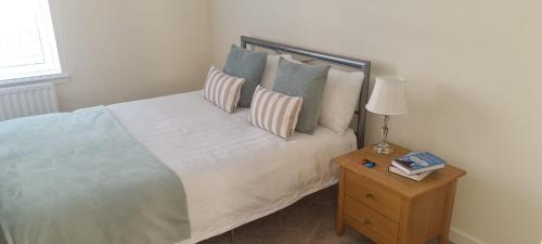 阿伯丁2 bed city centre executive apartment的一间卧室配有一张带枕头和桌子的床