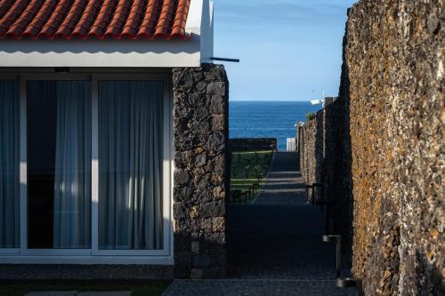 大里贝拉ENTRE MUROS - Turismo Rural - Casa com jardim e acesso direto ao mar的从大楼外欣赏海景
