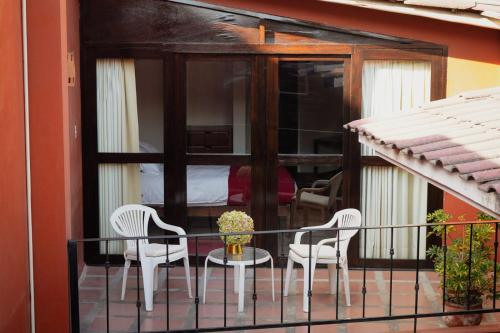 卡哈马卡Hotel Pilancones的阳台配有两把椅子、一张桌子和一张床