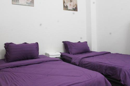 关丹Kuantan Homestay Best Facility Wifi BBQ Viu的紫色床单的客房内的两张床