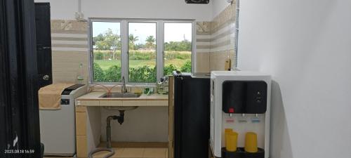 TuaranSantai Homestay的一间带水槽和冰箱的小厨房