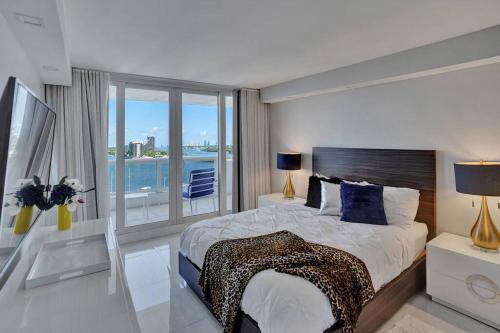 迈阿密A Wave From It All! Direct water views!的一间卧室设有一张大床和一个大窗户