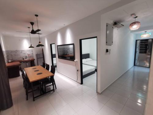居林Kulim Mini HomeStay的一间带桌子的客厅和一间带厨房的房间
