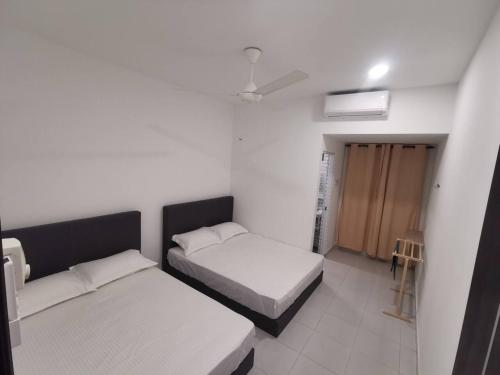 居林Kulim Mini HomeStay的一间卧室设有两张床,卧室内有一扇门
