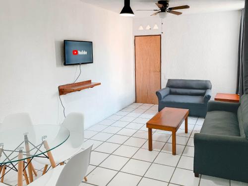 巴亚尔塔港Departamentos 1E的客厅配有沙发和墙上的电视