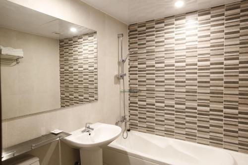 太白Ramada Taebaek Hotel的浴室配有盥洗盆、卫生间和浴缸。