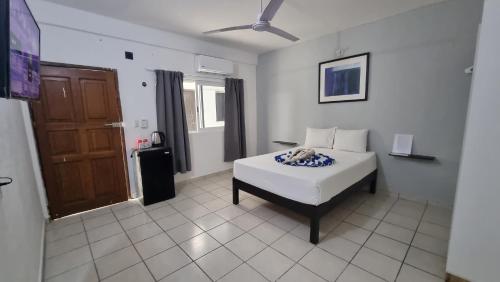 普拉亚卡门Casa Maria Fernanda的卧室配有白色的床和棕色的门。