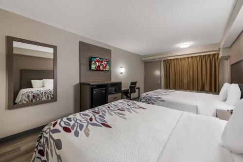 希科里锡克里红屋顶客栈的酒店客房,设有两张床和镜子