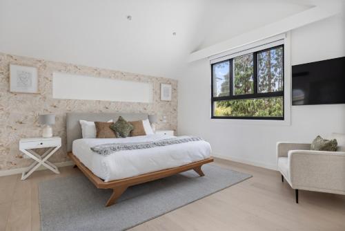 悉尼ANGEL70 - Newtown Haven的一间卧室配有一张床、一台电视和一张沙发