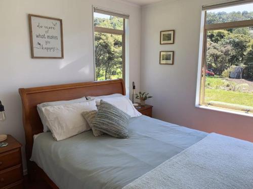 Paradise on the Hill ~ Tuateawa的一间卧室配有带两个枕头的床和窗户