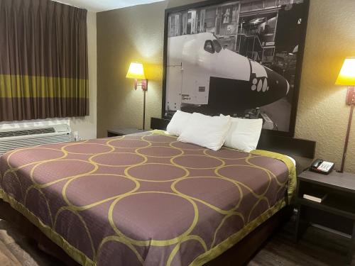 拉马克拉马克速8汽车旅馆的酒店客房设有一张床,墙上挂着一张照片