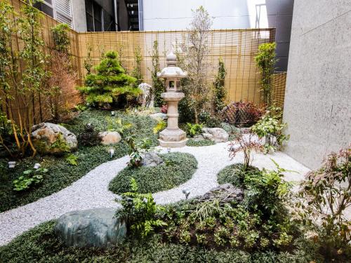 大阪大阪梅田由尼森酒店的一座花园,在一座建筑的中间有一个喷泉