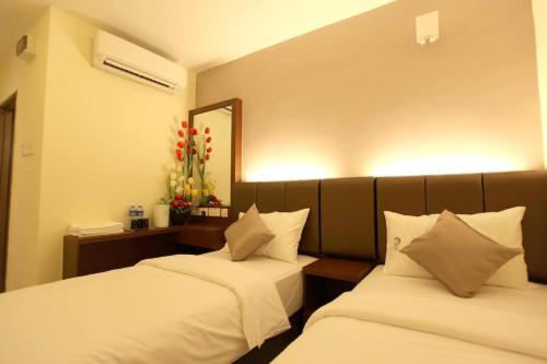 马六甲Avaria Signature Hotel的配有镜子的客房内的两张床