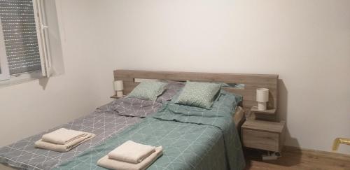 KomlóJószerencsét apartman的一间卧室配有一张带两个枕头的床