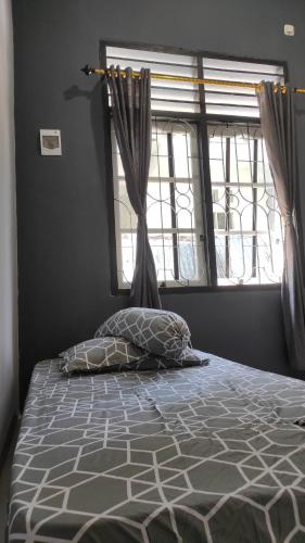 KaranganyarBabemhome的卧室内的一张床位,配有窗户和枕头