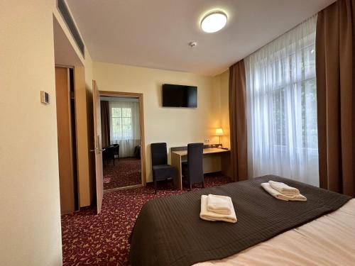 维尔纽斯城门酒店的酒店客房,配有带两条毛巾的床