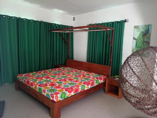 马哈赞加Villa sakinu的一间卧室配有床和绿色窗帘