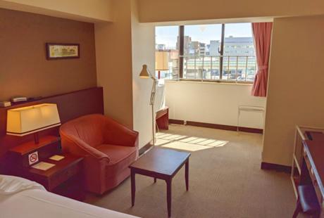 东京泽姆城市旅馆的一间客厅,客厅配有沙发和椅子,位于酒店的房间