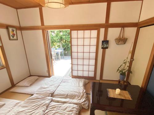 小豆岛星ノソラ的客房设有床、桌子和窗户。