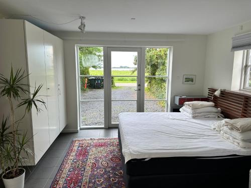 LangøLangø Feriecenter - Sea View的一间卧室设有一张大床和一个滑动玻璃门