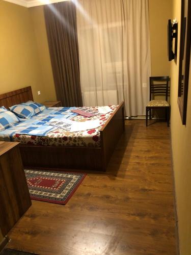 库塔伊西Hotel Nikea Paradiso的一间卧室配有一张铺有木地板的床和窗户。