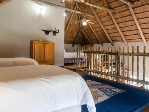 Dinokeng Game ReserveKlipdrift Sands Bush Camp的卧室配有白色的床和蓝色地毯。
