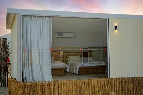 乌姆赛义德Al-Rahal Desert Camp的滑动玻璃门享有卧室的景致