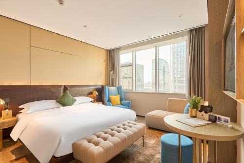 杭州ECHARM Plus Hotel - Hangzhou Binjiang Starlight Avenue的酒店客房配有一张床铺和一张桌子。