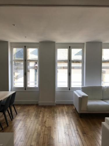 圣马洛Appartement de charme的带沙发、桌子和窗户的客厅