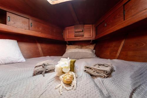 巴里Quo Vadis Yacht的一间卧室配有带毛巾和鲜花的床