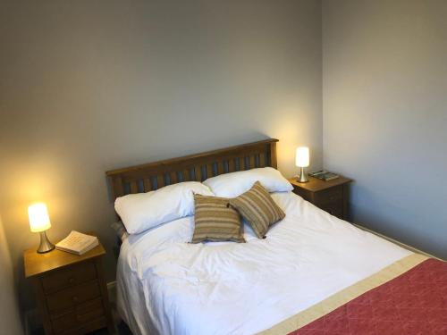 ClegganBruíon Connemara的卧室配有带两盏灯的白色床