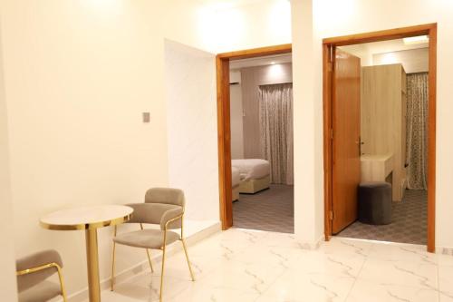 艾卜哈فندق المساء的一间带桌椅的房间和一间卧室