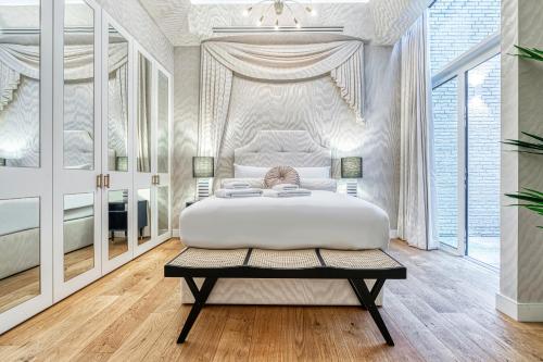 伦敦JOIVY Luxury flats near Big Ben and London Eye的白色卧室配有一张大床和一张桌子