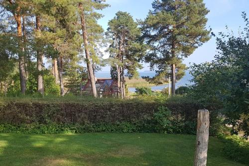 HammaröTrevligt gästhus nära Vänern och badplats的林木柱子,有树,有房子