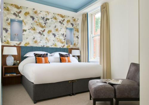 都柏林狄伦酒店的一间卧室配有一张大床和一把椅子