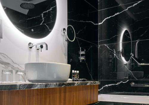都柏林狄伦酒店的黑色浴室设有水槽和浴缸。