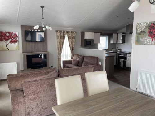 纽顿2 Bedroom Lodge - Honeysuckle 95, Trecco Bay的客厅配有沙发和桌子