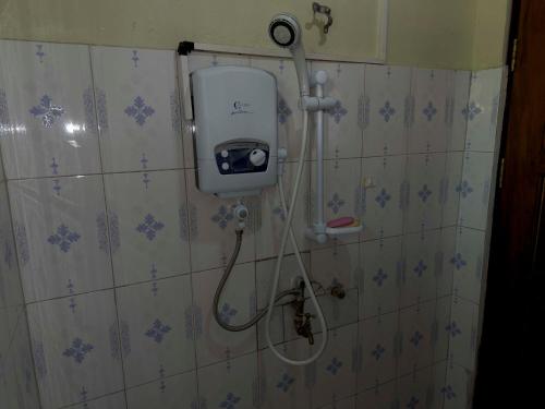 金贾Olive Palm Suites Jinja的墙上设有淋浴和肥皂机的浴室