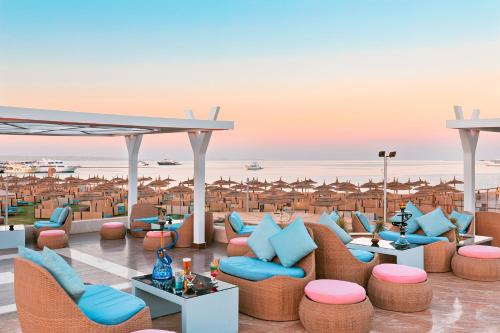赫尔格达Pickalbatros White Beach Resort - Hurghada的海滩景度假村设有桌椅