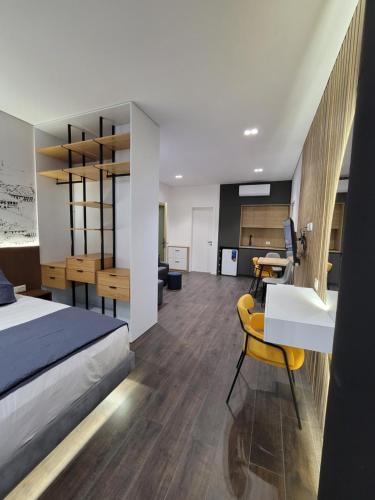吉诺卡斯特Jani Studio Apartments的一间带一张床和一张书桌的卧室和一间厨房