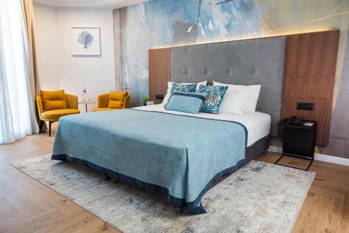 提比里亚凯撒提贝利亚斯高级酒店的一间卧室配有一张带蓝色毯子的大床