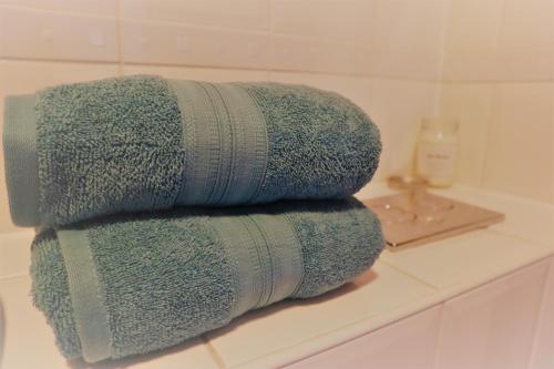 克劳利2BR Apt in Crawley w Parking - Near Gatwick的浴室的台面上摆放着一堆毛巾
