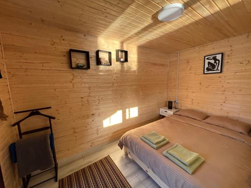 比卡兹Casa pe lac Bicaz的一间卧室设有一张床和木墙