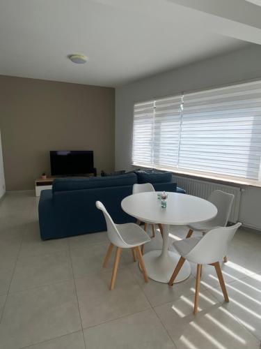 沙勒罗瓦1A01-Superbe appartement lumineux netflix gratuit的客厅配有桌椅和沙发