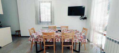 VodataMountain Pearls Home 9的一间带桌椅和电视的用餐室